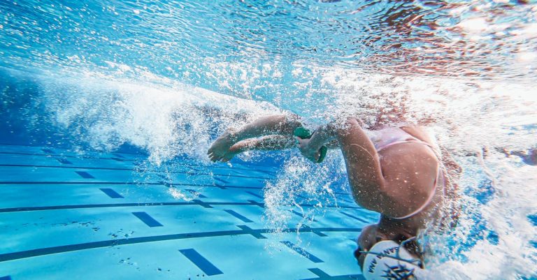 Underwater photo of a woman swimmer performing a flip turn in a swimming pool.